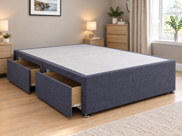 Grey upholstered divan storage base with two drawers in a modern bedroom – St James Bed Centre.