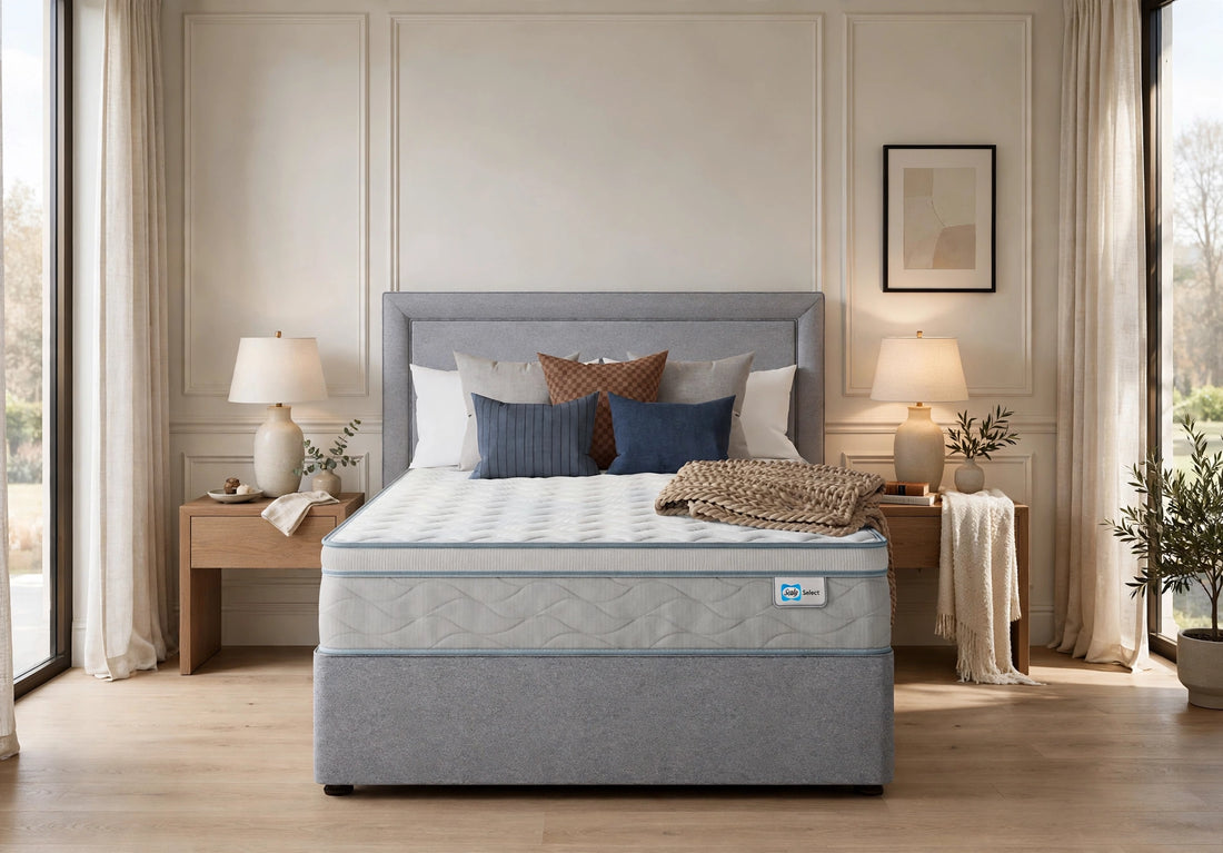 Sealy Select Holme mattress and divan bed with grey headboard styled with blue and brown luxury pillows and knitted throw in high-end luxury bedroom with wooden bedside tables
